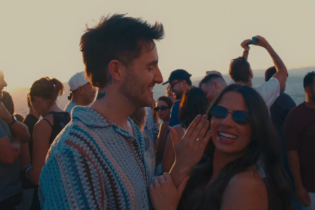 Luke and Lilian laughing in a golden-hour crowd